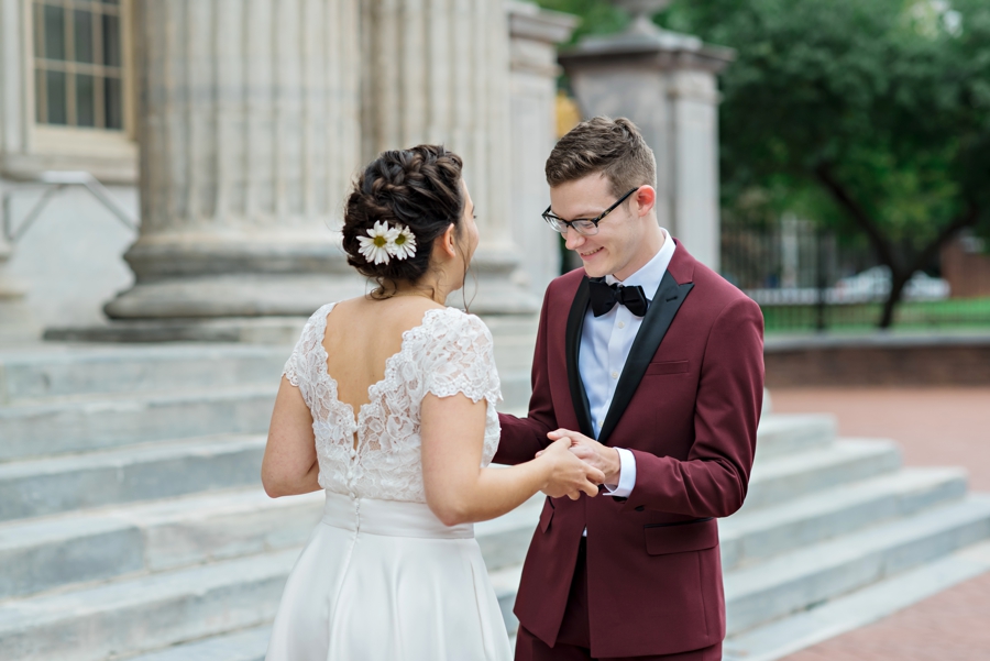 A happy wedding couple hold hands after their first look.